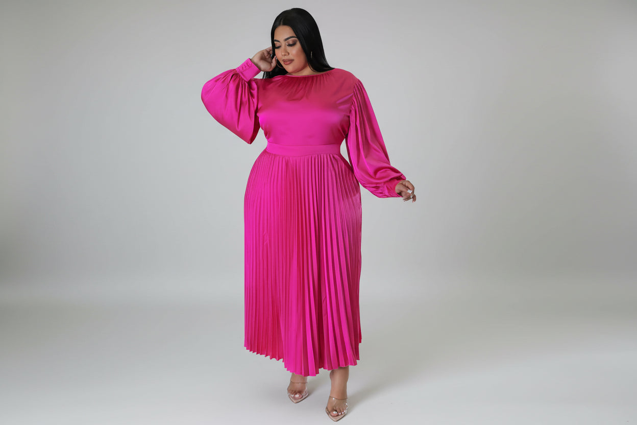 Woman wearing a bright pink pleated dress on a white background