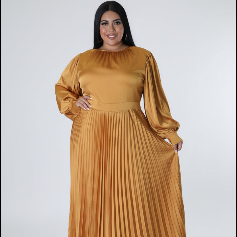 Woman wearing a mustard yellow pleated dress on a white background