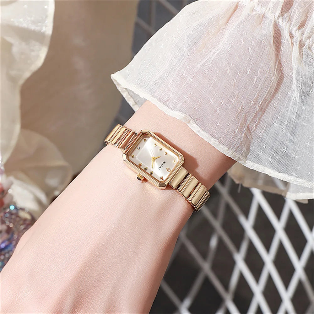 Gold wristwatch on a wrist with a blurred background