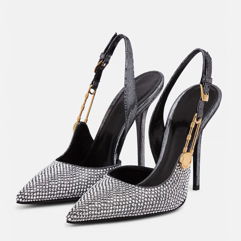 Black high-heeled shoes with rhinestone details on a white background