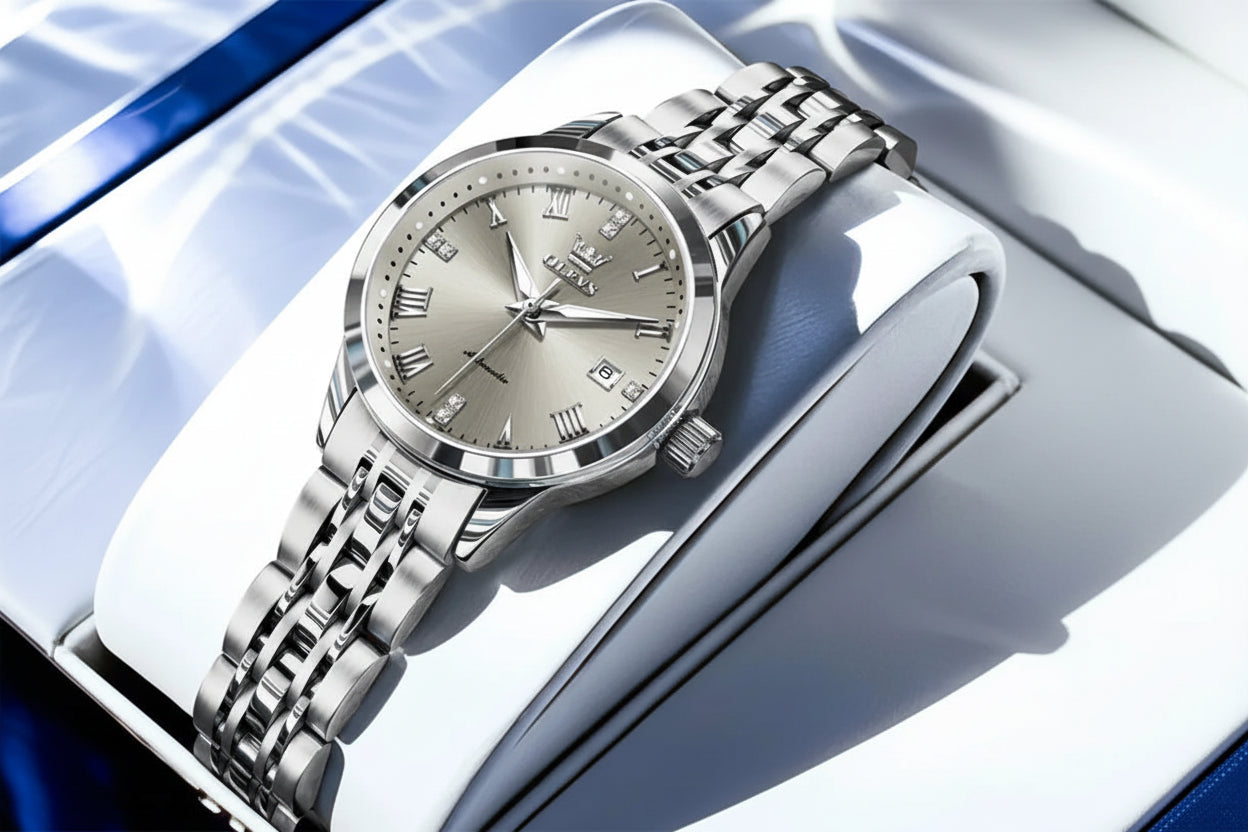 Silver watch with a detailed face on a white and blue background, featuring the OLEVS brand.