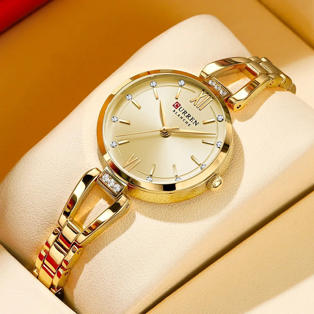 Gold wristwatch with diamond accents on a beige cushion